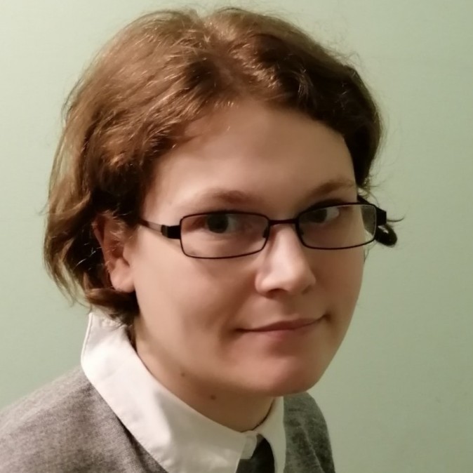 A close up picture of Phoebe; a woman with short brown hair and glasses.